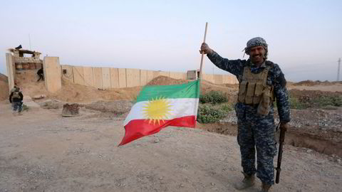 En irakisk soldat fjerner det kurdiske flagget fra oljebyen Kirkuk.