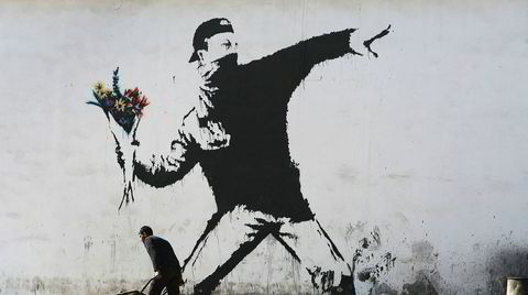 Aktivist. Banksy er elsket og hatet for sine lettfattelige politiske budskap. Dette veggmaleriet, kjent som «Flower Thrower», ble malt på en garasjevegg i Betlehem i 2005.