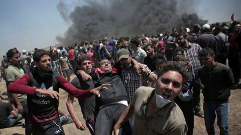 Palestinske demonstranter bærer en mann som ble skutt og såret. Foto: AP / NTB scanpix