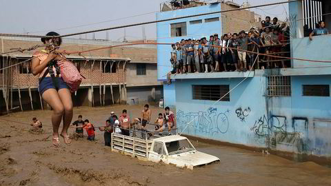 En kvinne blir heist i sikkerhet over en gate som er forvandlet til en elv i Lima i Peru.