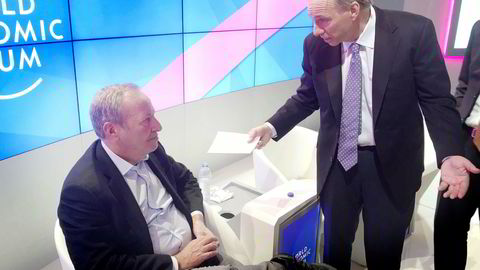 Tidligere finansminister Larry Summers og hedgefond-milliardær Ray Dalio diskuterer videre etter en paneldebatt under World Economic Forum i Davos.