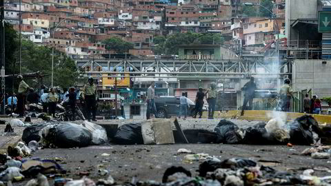 Opptøyene fortsetter i Venezuela, blant annet i forma av provisoriske sperringer i gatene i hovedstaden Caracas. View of a street blocked with garbage bags