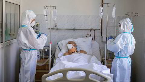 Helsearbeidere behandler en pasient for med koronavirus på en klinikk i Beograd, Serbia.