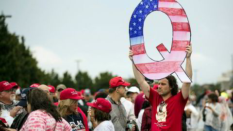 En demonstrant holder en stor Q mens han venter på å komme inn på et valgkampmøte med president Donald Trump i Pennsylvania i begynnelsen av august.