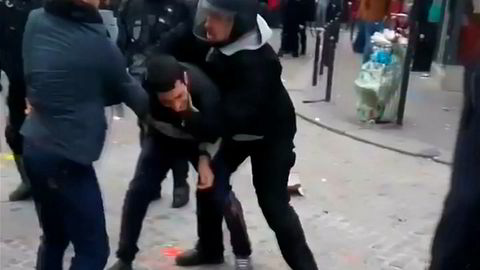 En film viser en av president Emmanuel Macrons øverste sikkerhetsfolk, Alexandre Benalla (til høyre) banke opp en demonstrant i Paris 1. mai. Saken er blitt en stor skandale i Frankrike.
