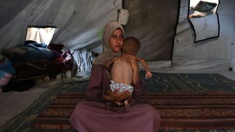 Den 31 år gamle palestinske kvinnen Hidaya holder sin sultende sønn Mohammed i et telt i en flyktningleir på Gazastripen. Militær intervensjon synes å være den eneste måten å stanse lidelsene.