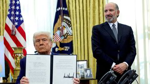 USAs president Donald Trump har her nettopp signertg en presidentordre om toll, flankert av handelsminister Howard Lutnick.