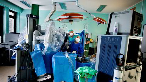 Anestesisykepleier Erik Helmich Pedersen (fra venstre) og operasjonssykepleier Josefine Waage gjennomfører en prostataoperasjon med en robot.