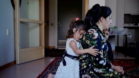 Homa Mohammadi sitter på gulvet i omsorgsboligen på Straume, litt utenfor Bergen. Datteren Maria holder rundt moren, som er utvist fra Norge. Ved siden av sitter sønnen Meriwan.