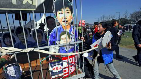 Motstandere av Park Geun-hye demonstrerte fredag med en pappfigur av den avsatte presidenten plassert bak lås og slå.