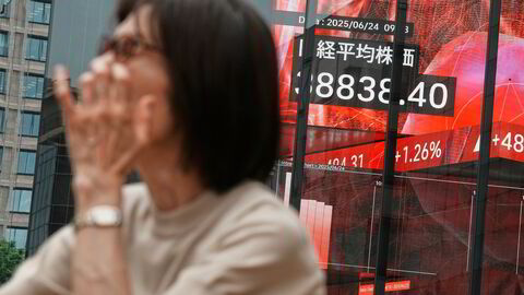 A person stands in front of an electronic stock board showing Japan's Nikkei index at a securities firm Tuesday, June 24, 2025, in Tokyo. (AP Photo/Eugene Hoshiko)