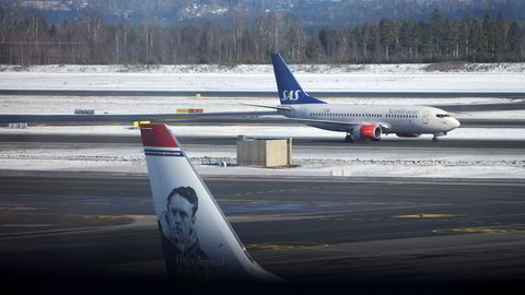 Avbildet er et SAS-fly og et Norwegian-fly på Oslo Lufthavn.