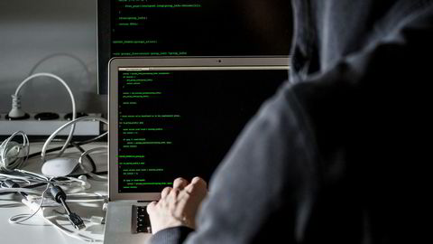 Illustrasjonsbilde: Mann som sitter bak datamaskin og hacker. Foto: Fredik Bjerknes.