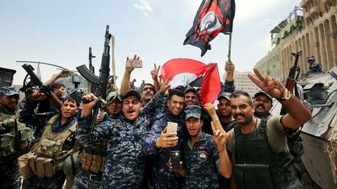 Medlemmer av Iraks føderale politi feirer med landets flagg i gamlebyen i Mosul etter seieren mot IS i helgen.