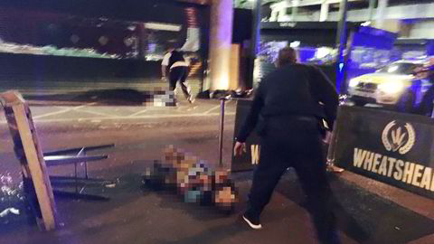 En bevæpnet polititjenestemann står over det som antas å være en av de tre mistenkte som skal være skutt av politiet i London. Personen på bakken var iført noe som ligner på en bombevest.
