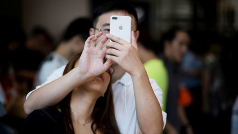 Apple er et av flere amerikanske selskaper som kan risikere tilbakeslag i Kina hvis Donald Trump innfører straffetoll mot landet. Her prøver et et kinesisk par Apples Iphone 7 i Shanghai i september.