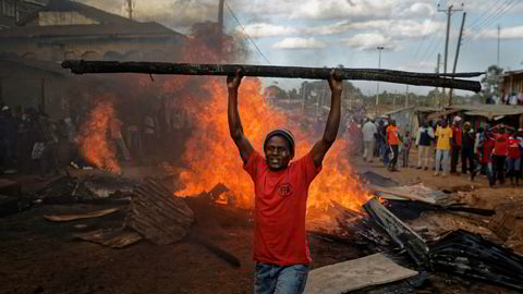 En opposisjonstilhenger foran en brennende barrikade som er laget av materialer fra en eiendom som tilhører en mann fra kikuyu-folket. President Uhuru Kenyatta tilhører kikuyu-folket. Foto: Ben Curtis / AP / NTB scanpix