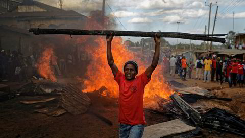En opposisjonstilhenger foran en brennende barrikade som er laget av materialer fra en eiendom som tilhører en mann fra kikuyu-folket. President Uhuru Kenyatta tilhører kikuyu-folket. Foto: Ben Curtis / AP / NTB scanpix
