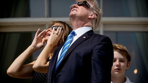 President Donald Trump under solformørkelsen mandag sammen med konen Melania og sønnen Barron. Nå vil Trump forbedre forholdet til både republikanere og næringslivet gjennom skattereform.  Andrew Harnik/AP/NTB scanpix