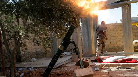 Et medlem av den USA-støttede opprørsalliansen SDF avfyrer en bombekaster i Raqqa i juli i år. Foto: AP/NTB scanpix