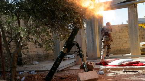 Et medlem av den USA-støttede opprørsalliansen SDF avfyrer en bombekaster i Raqqa i juli i år. Foto: AP/NTB scanpix