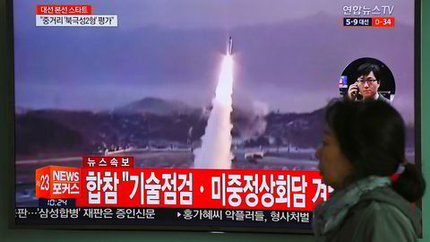 På bildet passerer en dame en tv-skjerm i Seoul i Sør-Korea onsdag som viser et bilde av en Nord-Koreansk rakettoppskyting.