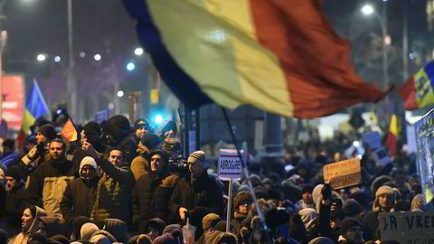 Det rumenske flagget vaier i luften under store demonstrasjoner mot Romanias nye regjeringen etter et hastevedtaks om dekriminaliserer korrupsjon.