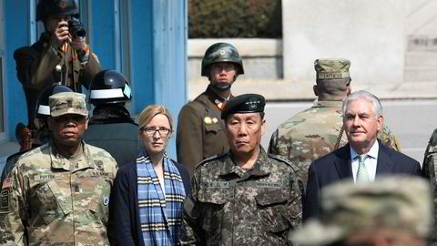 USAs utenriksminister Rex Tillerson (til høyre), avbildet på grensen mellom Sør-Korea og Nord-Korea, med nordkoreanske soldater utstyrt med fotoapparat bak seg.